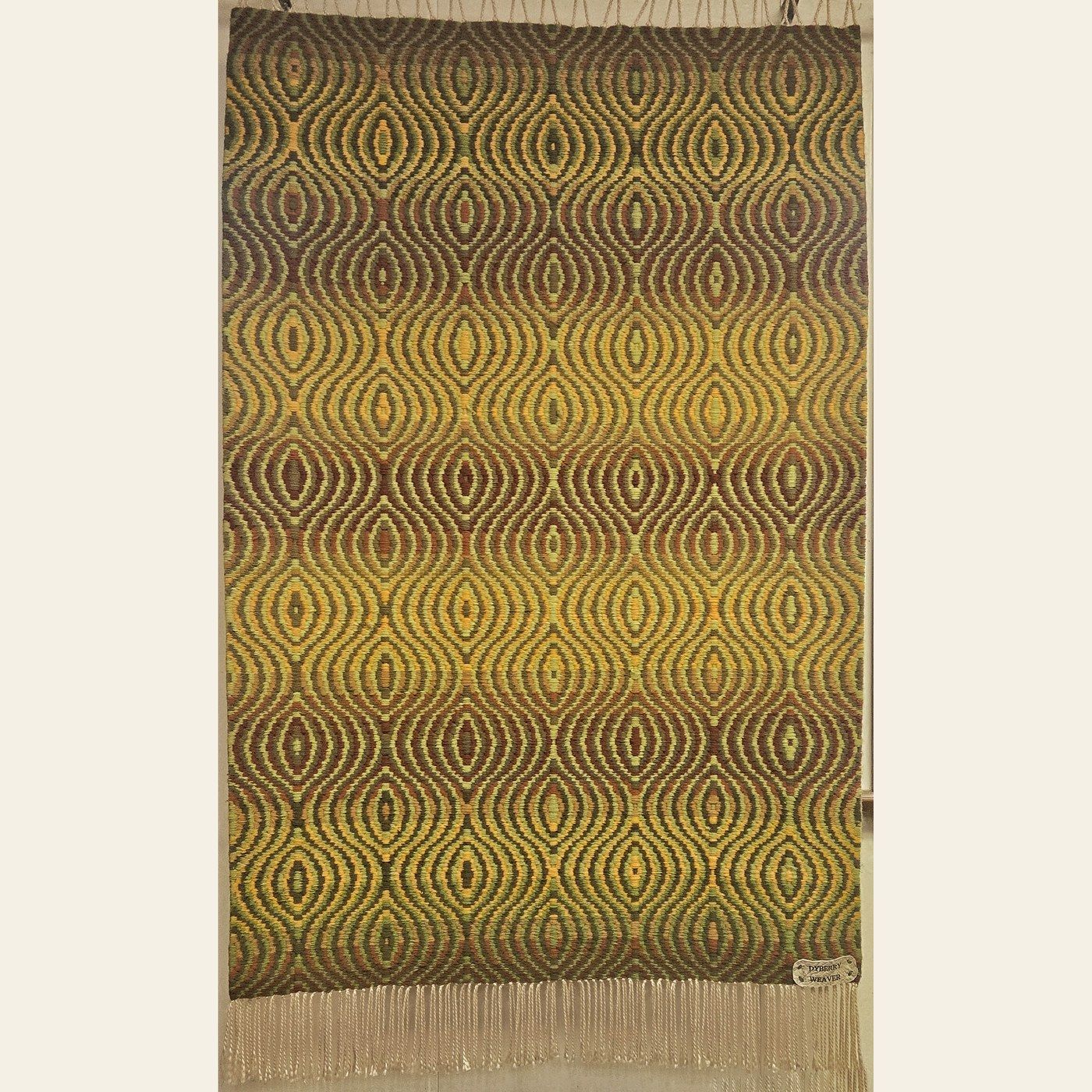 Hand-woven rug by Charles H. Blanchard, the Dyberry Weaver of Narrowsburg NY, in an undulating ogee pattern of olive green, gold and brown with cream fringe