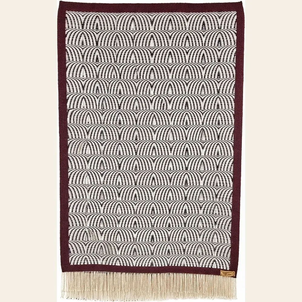 Hand-woven wool throw by Charles H. Blanchard, the Dyberry Weaver of Narrowsburg NY, with a repeating arch pattern in black and cream bordered in deep burgundy and finished with cream fringe