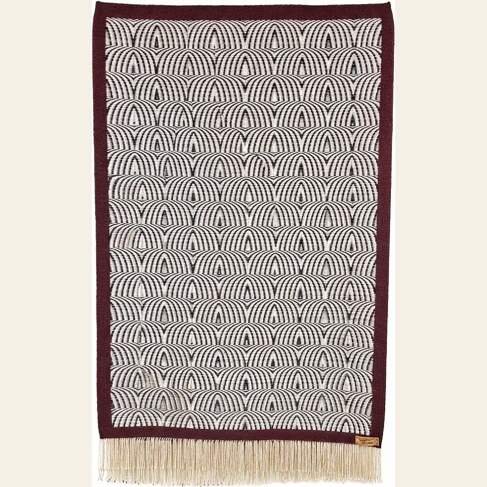 Hand-woven wool throw by Charles H. Blanchard, the Dyberry Weaver of Narrowsburg NY, with a repeating arch pattern in black and cream bordered in deep burgundy and finished with cream fringe