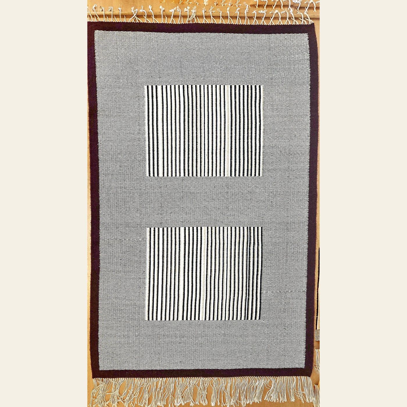 Hand-woven wool rug by Charles H. Blanchard, the Dyberry Weaver of Narrowsburg NY, in grey and cream with two finely striped panels and a dark brown border