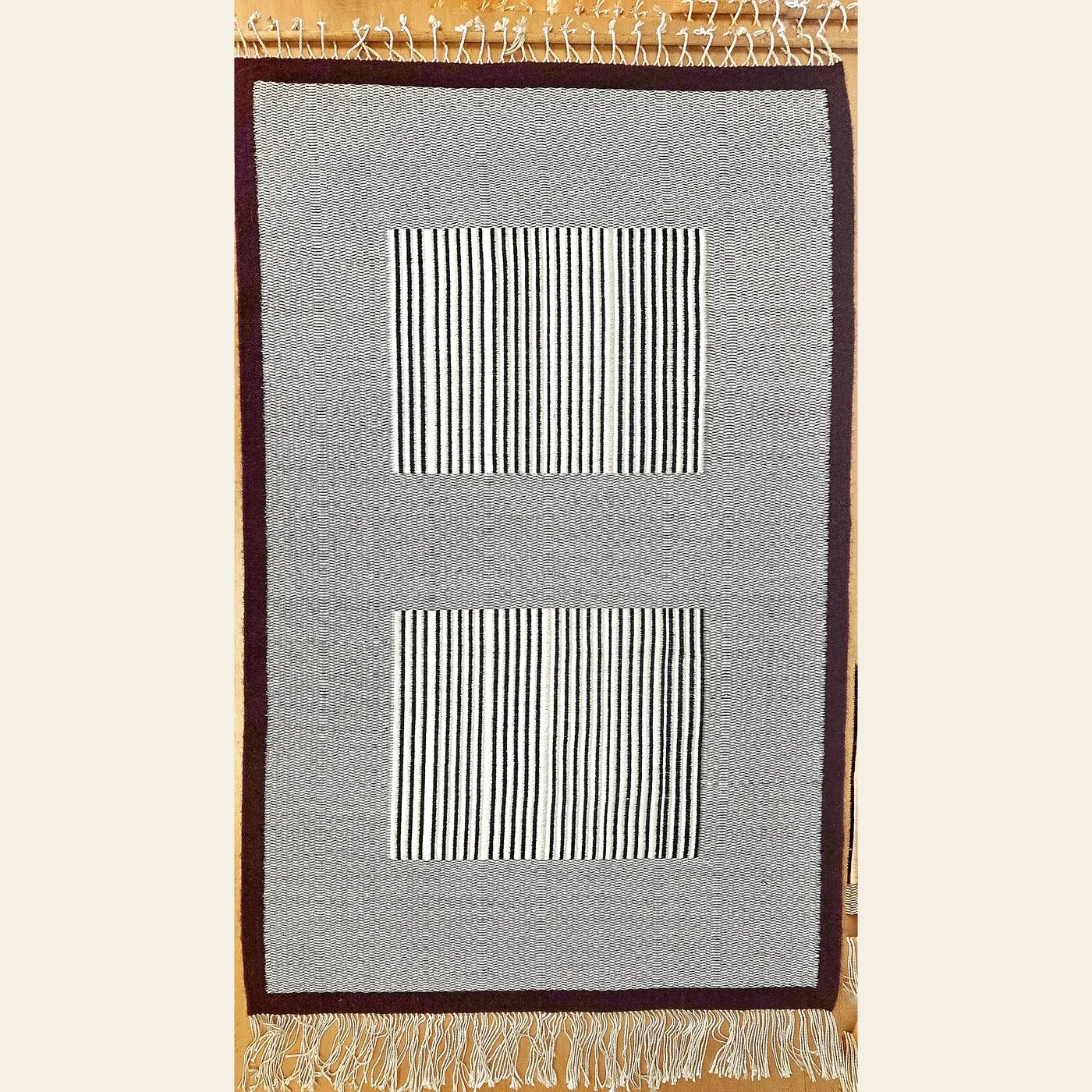 Hand-woven wool rug by Charles H. Blanchard, the Dyberry Weaver of Narrowsburg NY, in grey and cream with two finely striped panels and a dark brown border