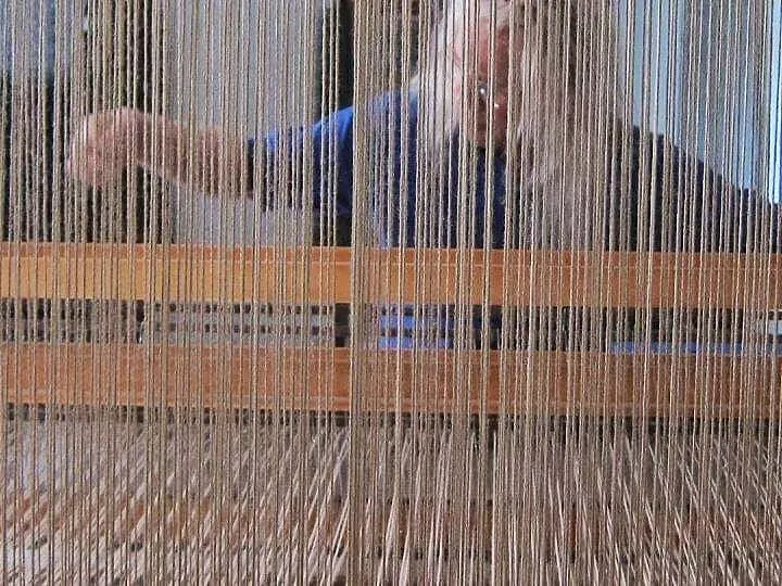 Charles H. Blanchard seen through the warp threads of his loom while weaving in his Narrowsburg NY studio